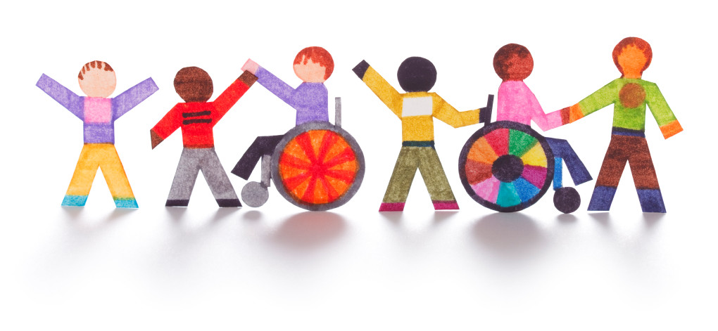 A colorful illustration depicting six paper cutout-style human figures, including two in wheelchairs, holding hands to symbolize inclusivity, diversity, and unity."