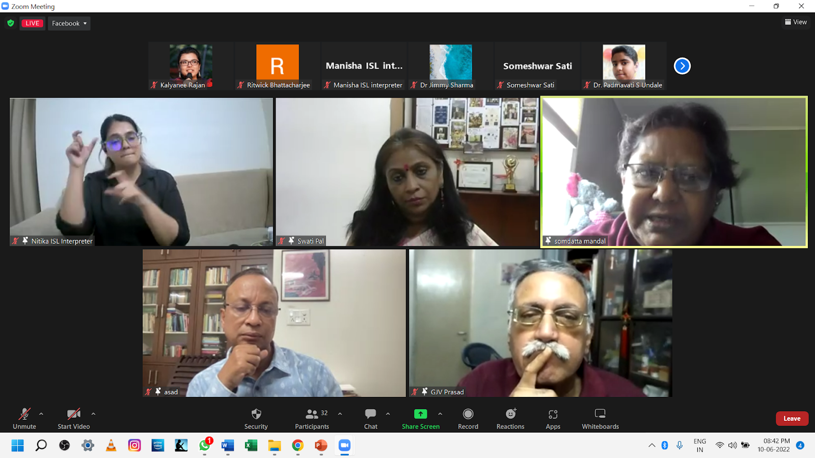 A screenshot of a Zoom meeting shows five participants in various video frames. The top row features an ISL interpreter, a woman, and a man in the main active speaker frame. The bottom row shows two men, one with his hand on his chin, and another with a mustache.
