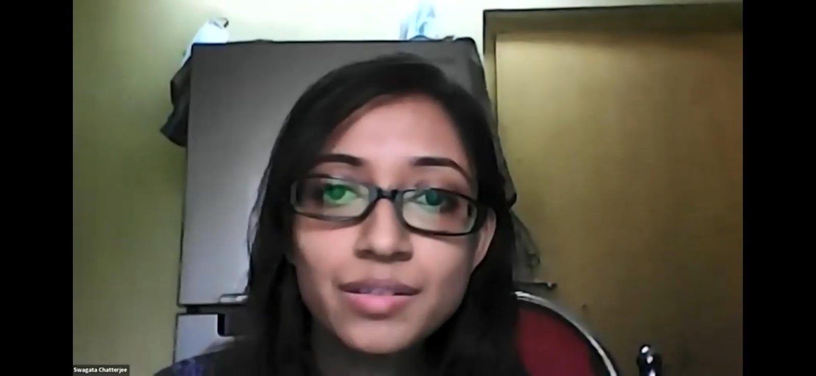 A headshot of Swagata Chatterjee, a young woman with dark hair and glasses, looking directly at the camera with a subtle smile, appearing in a video call frame.