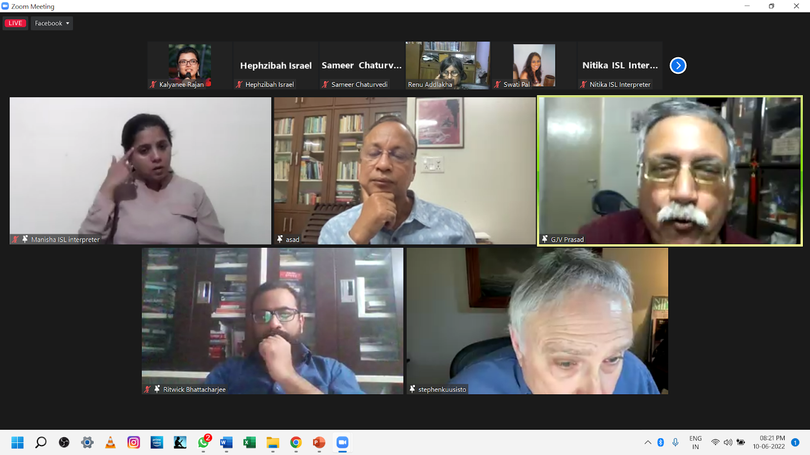 A screenshot of a Zoom meeting with several participants, some of whom are visible in their individual video feeds. One person in the top left is an ISL interpreter.