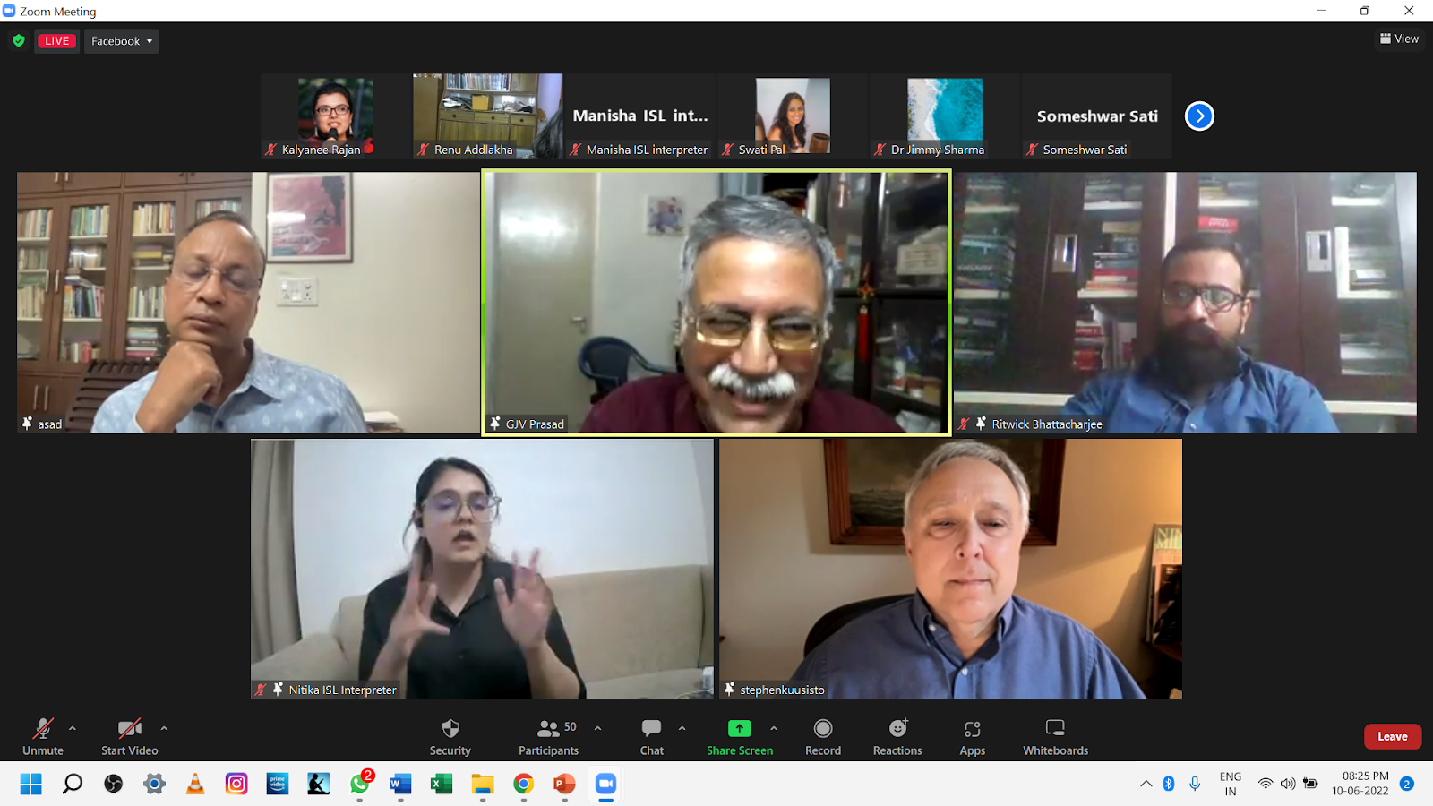 A screenshot of a Zoom meeting with five participants visible. Three men are in the top row, and a woman acting as an ISL interpreter and another man are in the bottom row. The central speaker has a mustache and glasses.