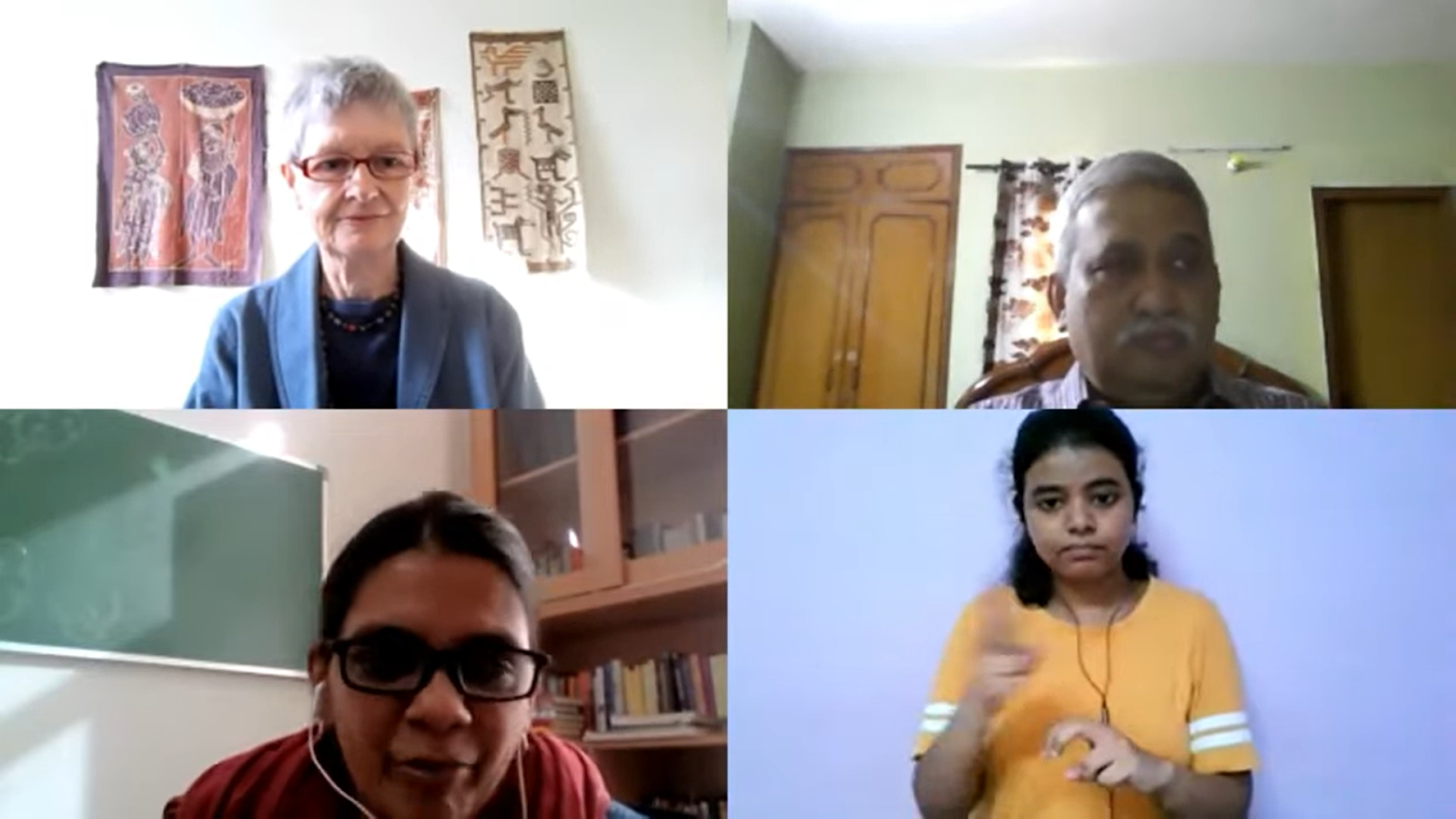 four people having a webinar in an online mode and one ISL interpreter discussing.