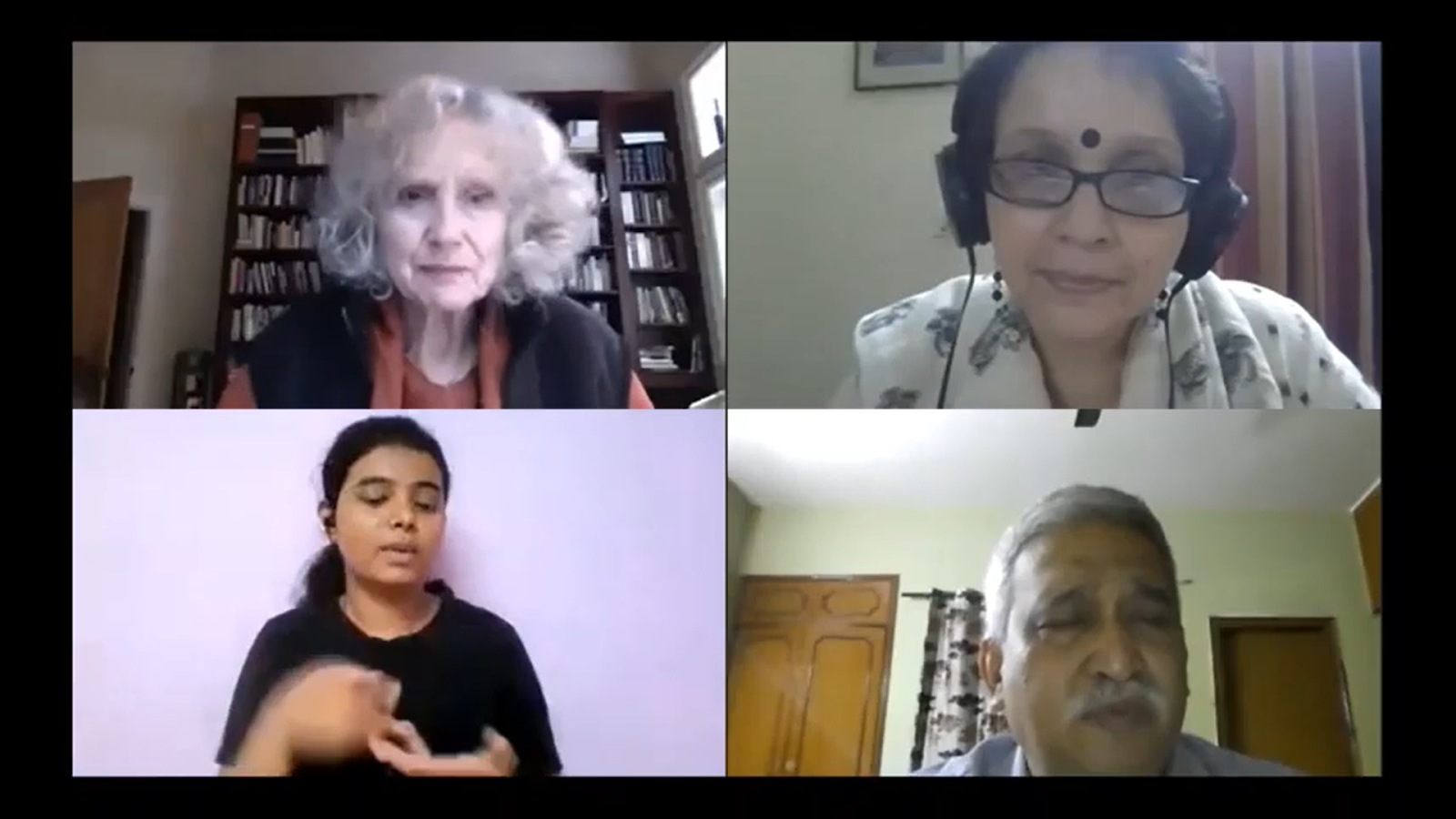 Four people are sitting with someshwar sir and one ISL interpreter doing sign language.